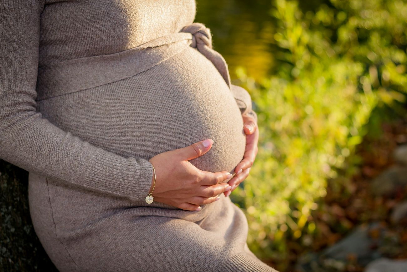 Femme enceinte, les mains posées sur son ventre